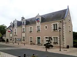 Photographie d'un bâtiment dont la façade est ornée de drapeaux français.