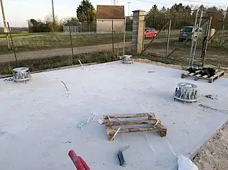 Plate-forme en béton avec les points d'ancrage du pylône.