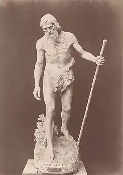 Statue d'un homme âgé portant un bâton.