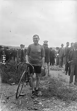 Photographie en noir et blanc d'un homme qui tient un vélo.