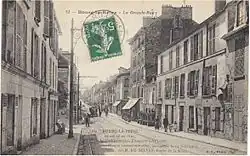 Carte postale figurant une rue en enfilade.