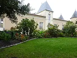 Château vu du parc avec massif de fleurs.