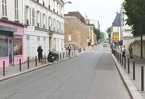 La rue de la Santé vue depuis le boulevard Auguste-Blanqui. À gauche, les murs de la prison de la Santé.