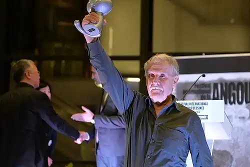 Hermann brandissant le trophée.