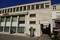Arcade donnant accès à la rue du Plat-d'étain, état en décembre 2013. Une enseigne installée récemment nuit à la lisibilité du portique.