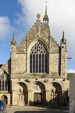 Photo d'une façade d'église dont le bas est roman et le haut gothique.