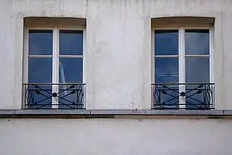 Fenêtre et garde corps à flèches entrecroisées.