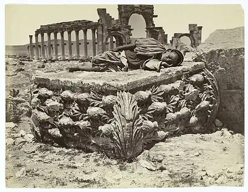 Enfant bédouin endormi sur un chapiteau de colonne antique.