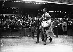 Photo d'une homme porté par deux autres sur leurs épaules.