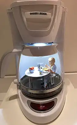 des personnages miniatures font la queue devant la banque alimentaire installée dans un sac de provisions