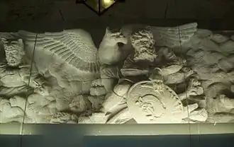 Une scène sculptée sur une frise, à l'intérieur de la tombe, représentant l'oiseau mystique Simurgh et le héros.