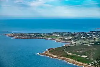 Vue aérienne de deux pointes s'avançant dans la mer. La première, sur la gauche est couverte de champs tandis que la première est couverte de landes.