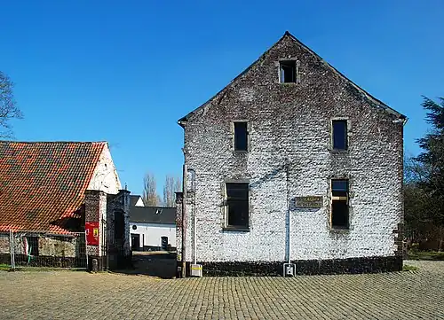 Le pignon du corps de logis et la grille d'accès.