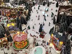 Village de Noël avec piste de ski et carrousel.