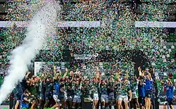 Photographie d'un groupe de sportifs de face en train de célébrer une victoire