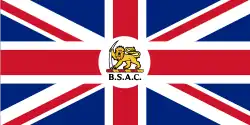 Un Union Jack, portant en son centre un emblème représentant un lion tenant une défense d'éléphant au-dessus des lettres « BSAC"