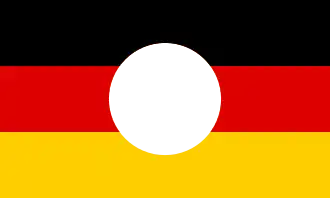 Drapeau de RDA à l'emblème découpé par protestation (1989).