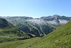 Une montagne verdoyante. On distingue un chemin dans la vallée, en contrebas.