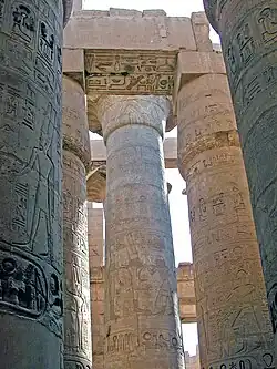 Colonnes, chapiteaux en lotus ouvert (partie ancienne, centrale, d'Amenhotep&nbsp;III) et fermé (travées latérales, de Ramsès&nbsp;II). Colonnes gravées en bas-relief dans le creux par Ramsès&nbsp;II (au Sud)