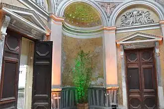 Vue intérieure du cabinet d’histoire naturelle, il y a une porte de chaque côté de la photo et une niche avec voûte en cul-de-four au centre. Éclairage naturel grâce à la verrière.