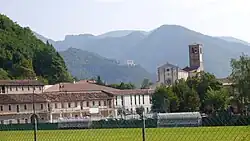 Photographie couleur de bâtiments monastiques situés au pied de montagnes.