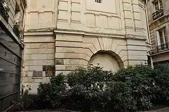 Partie basse de la fontaine, cachée derrière un épais feuillage.