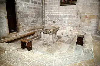 Les fonts baptismaux, du XIIIe siècle, flanqués de quatre fûts de colonne portant un visage en guise de chapiteau.