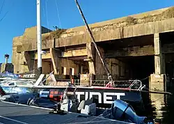 Avant d'un voilier noir amarré au ponton.