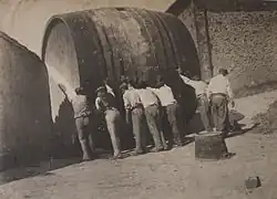 Vignerons audois entrant un foudre dans un hangar.