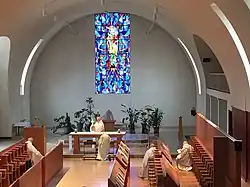Photographie d'une église moderne dans laquelle des moines mettent en place l'ostension de l'eucharistie