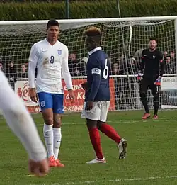 Photographie prise lors du match opposant la France à l'Angleterre pour les qualifications du championnat d'Europe de football des moins de 19 ans 2015 au stade Louis-Villemer de Saint-Lô le 31 mars 2015. Ici, Ruben Loftus-Cheek, Olivier Kemen et Florian Escales en arrière-plan.