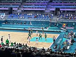 Photographie d'une salle assistant à une rencontre entre une équipe habillée en blanc, la France, et une en verte, le Nigéria.