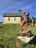 Sculpture en bois du mouflon (l'animal emblématique des Cévennes) et la chapelle protestante du village de L'Espérou, à proximité de la route départementale « D 986 » en direction du col de la Serreyrède.