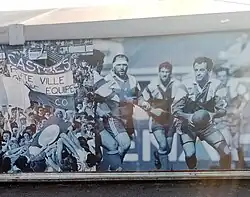 Affiches du chapiteau avec, à droite, le capitaine Francis Rui ballon en main et le Brennus polémique.