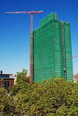 Photographie d'une tour de bureau entourée d'échafaudages.