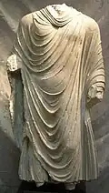 Bouddha debout, variante du type de la monnaie d'or de Kanishka au Bouddha. Schiste. Gandhara, IIe&nbsp;siècle (?). Museo d'Arte Orientale, Turin