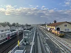 Les voies de services à droite et le bâtiment marchandises. Une Class 66 et sa rame y stationnent en attendant le départ.