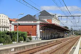 Photographie de la gare de Saint-Jean-de-Luz - Ciboure, surplombant deux voies ferrées.