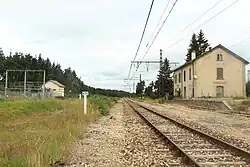 Vue de la voie, de l'ancien bâtiment voyageurs d'un côté de la voie et de la sous-station électrique de l'autre.