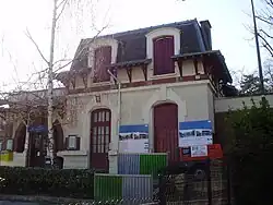 Photographie couleur. Façade d'un corps de bâtiment avec des affiches de chantier.