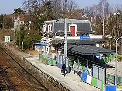 Photographie couleur. Vue surplombante d'un bâtiment entouré de palissades sur un quai.