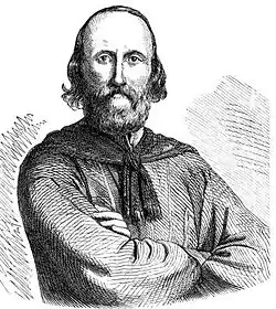 Portrait d'un homme tenant ses bras croisés.