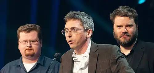 Les scénaristes, de gauche à droite, Jay Pinkerton, Erik Wolpaw et Chet Faliszek, recevant leur récompense de la meilleure narration pour Portal 2 au Game Developers Conference de 2012.