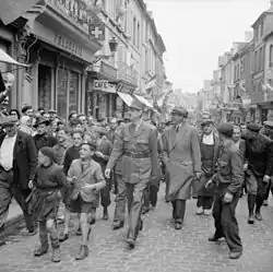 Le général de Gaulle marchant dans les rues de Bayeux le 14 juin 1944.