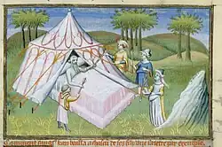 Old man lying in a bed with four men standing around.