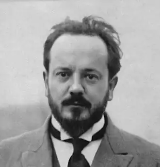 Photographie en noir et blanc et en buste d'un homme portant une moustache et une barbiche.