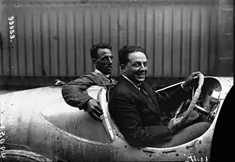 Photo d'un homme et de son passager prenant la pause au volant d'une voiture.