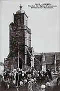 Glomel : cérémonie au cimetière devant l'église Saint-Germain l'Auxerrois au début du XXe&nbsp;siècle (carte postale Émile Hamonic).