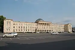 Bâtiment blanchâtre, très large mais ne comportant que trois niveaux. Au centre, la façade est ornée de colonnes et on aperçoit un dôme sur le toit.