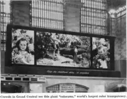 Affiche Colorama en 1950 dans le grand hall de Grand Central Terminal représentant une scène de la vie familiale